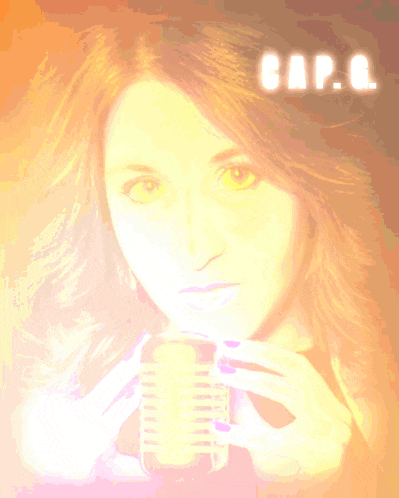 a woman is holding a microphone in front of a yellow background that says cap