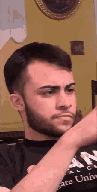 a man with a beard is wearing a shirt that says gate university on it