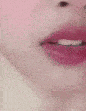 a close up of a woman 's face with red lipstick and white teeth