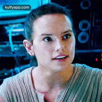 a close up of a woman 's face with a surprised look on her face in a room .