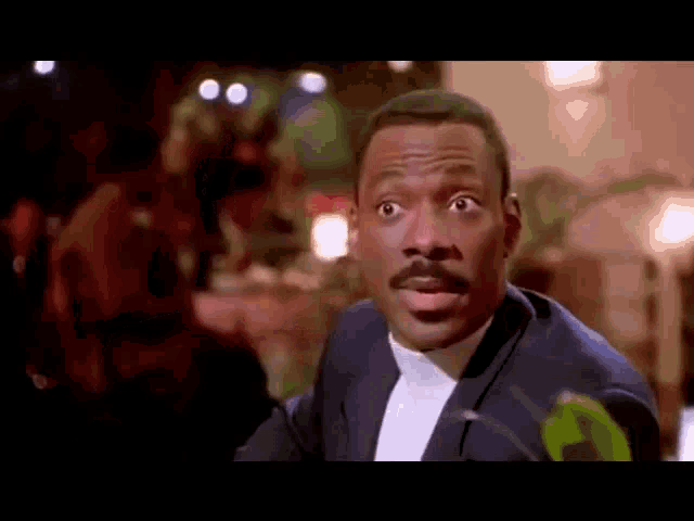 a man in a tuxedo is making a funny face .