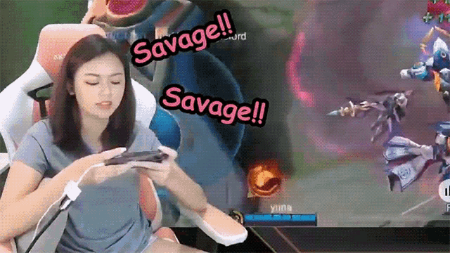 a woman sitting in a chair playing a video game with savage written on the screen