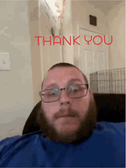 a man wearing glasses and a blue shirt says thank you in red letters