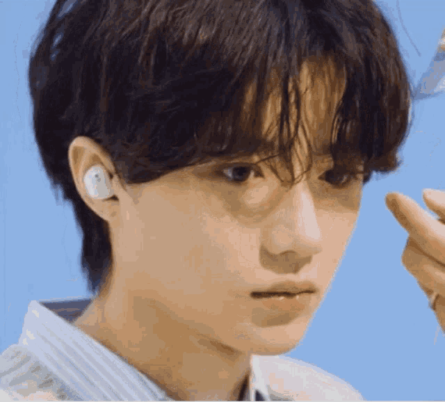 a close up of a young man wearing a pair of earbuds .