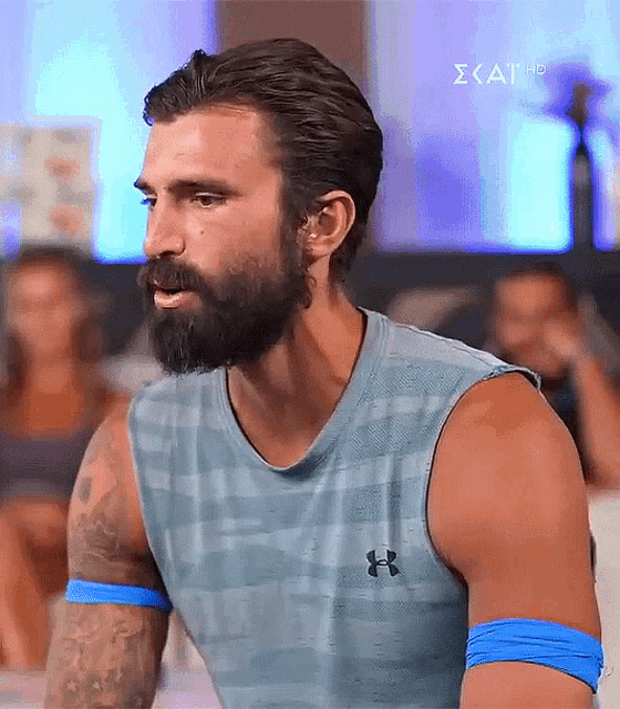 a man with a beard wearing an under armour tank top