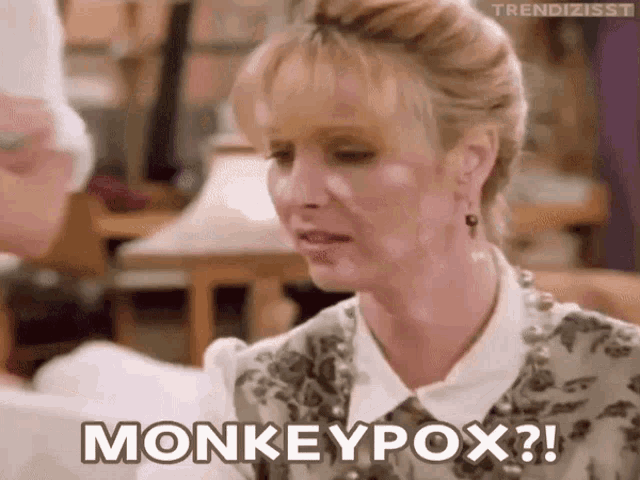 a woman is sitting at a table and saying monkeypox
