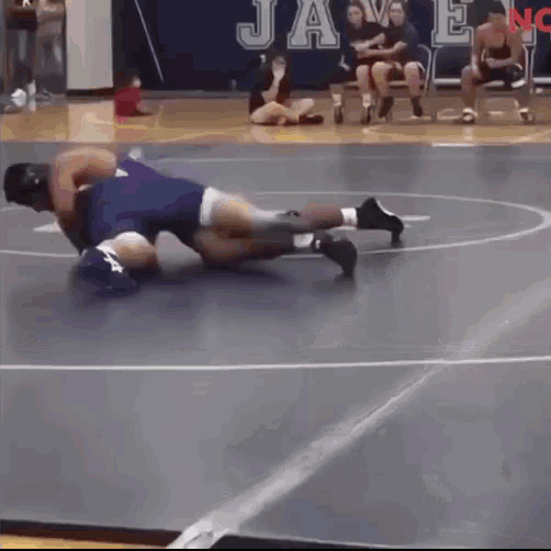 a wrestling match takes place in front of a banner that says jays