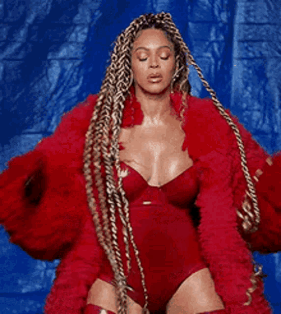 a woman in a red bodysuit is wearing a red fur coat and stockings .