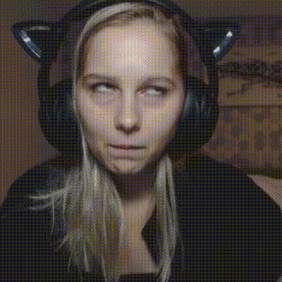 a woman wearing headphones with cat ears on her head makes a funny face