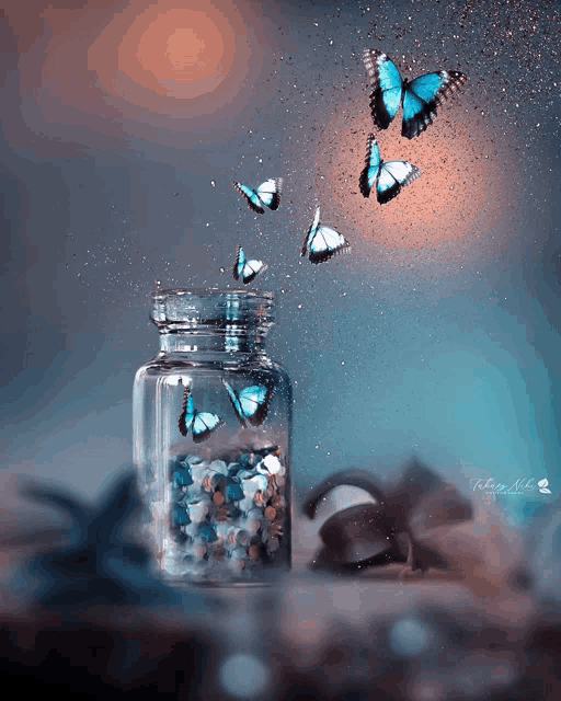 butterflies are flying out of a glass jar with pills in it