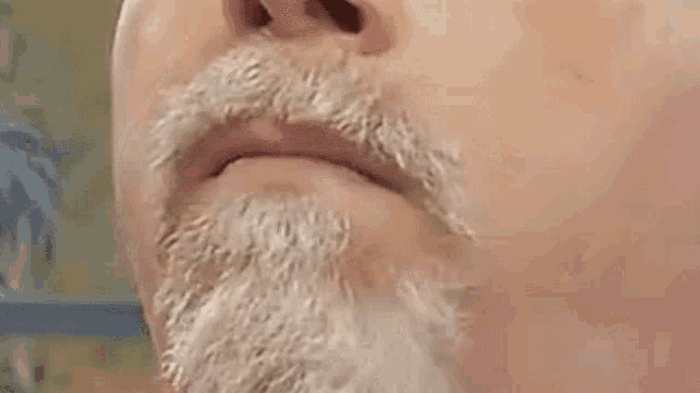 a man with a beard and mustache is making a funny face .