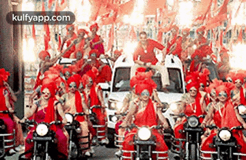 a large group of people are riding motorcycles down a street in a parade .