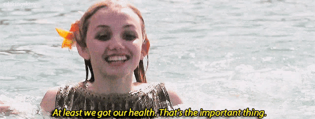 a woman in the water with the words at least we got our health