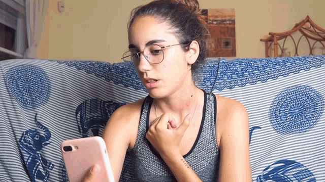 a woman sitting on a couch looking at a cell phone