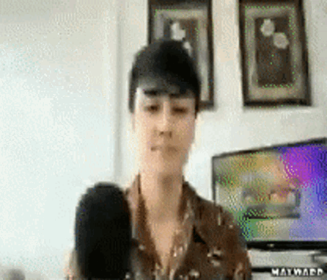 a woman is holding a microphone in front of a television that says matward on it