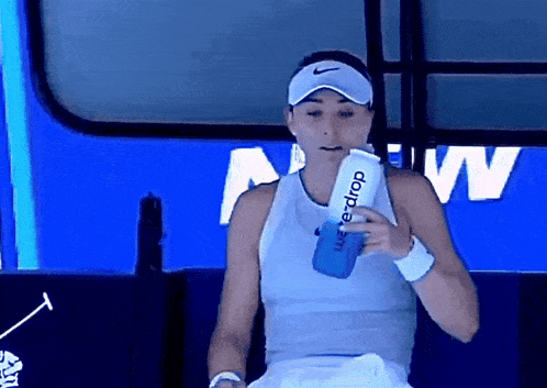 a woman holding a bottle that says water drop