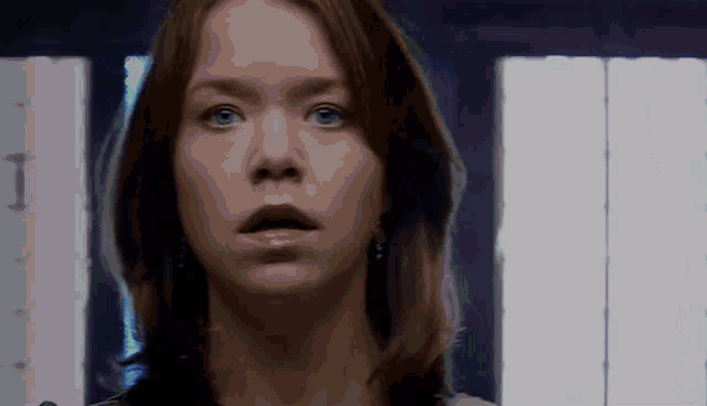 a woman with a surprised look on her face looks at the camera