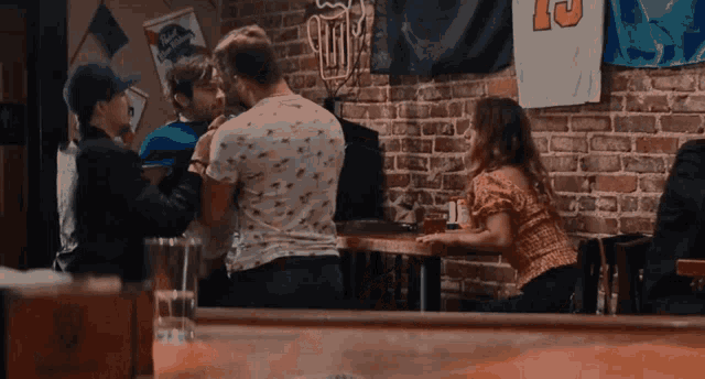 a group of people are standing around a table in a bar with a sign that says ' beer '