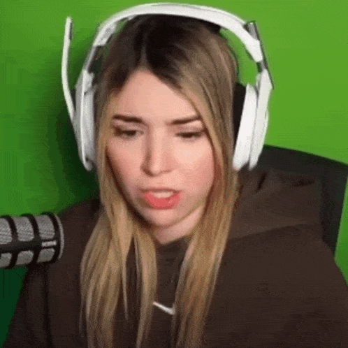 a woman wearing headphones is sitting in front of a microphone .