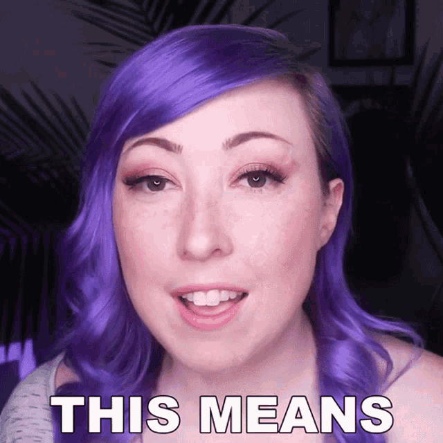 a woman with purple hair says " this means " in front of her face