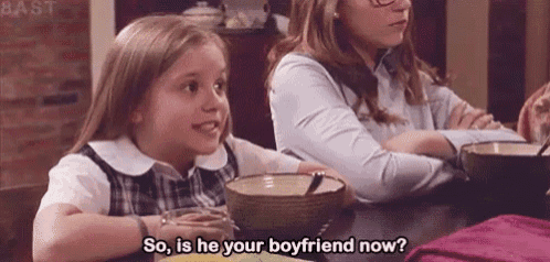 a little girl is sitting at a table with a bowl of soup and a woman .
