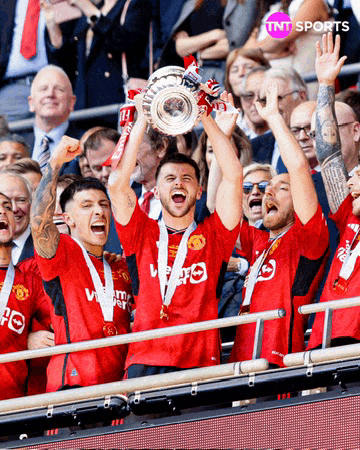 a group of soccer players holding up a trophy with tnt sports on the bottom right