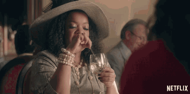 a woman drinking from a glass with a netflix logo on the bottom right