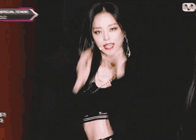a woman in a crop top is standing in front of a sign that says special stage