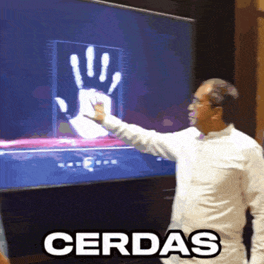 a man is pointing at a hand on a screen that says cerdas