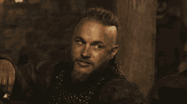 a man with a braided ponytail is drinking from a glass