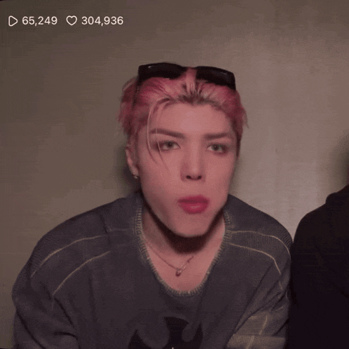 a man with pink hair has 65,249 likes and 304,936 hearts