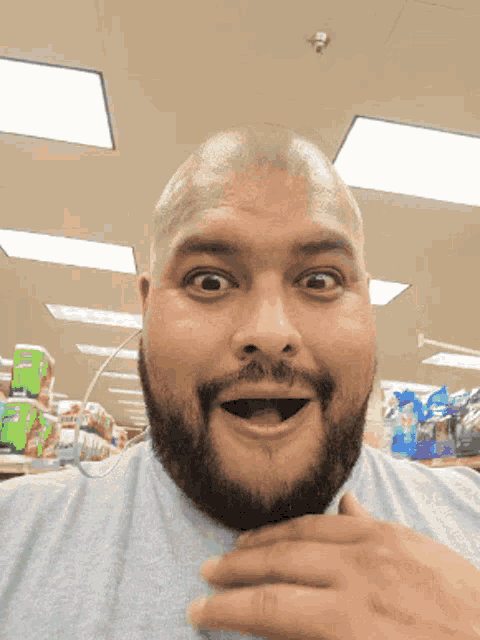 a bald man with a beard is making a surprised face
