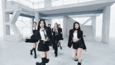 a group of women are dancing in front of a building with stairs