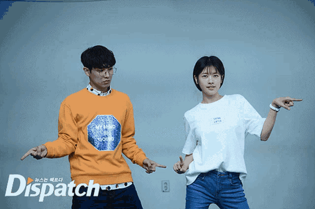 a man wearing an orange sweatshirt that says my mind is bound stands next to a woman wearing a white t-shirt