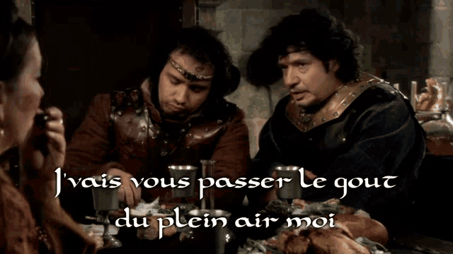two men are sitting at a table with the words j vais vous passer le gout du plein air moi on the bottom