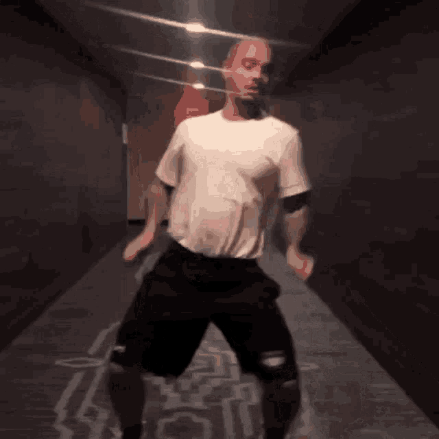 a man in a white shirt and black shorts is dancing