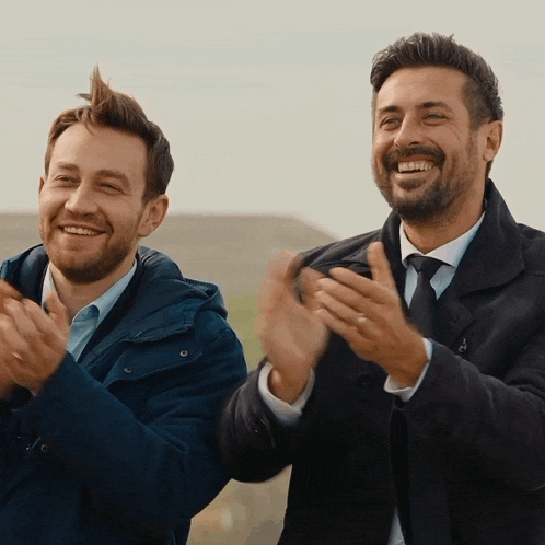 two men are clapping their hands together and one has a mohawk