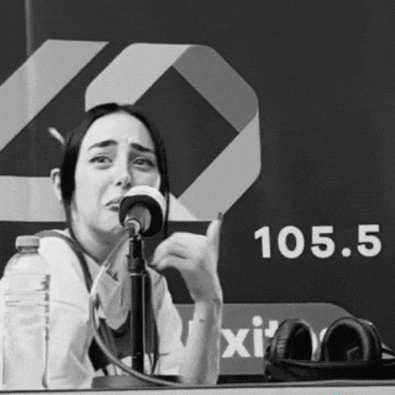 a woman singing into a microphone in front of a sign that reads 105.5