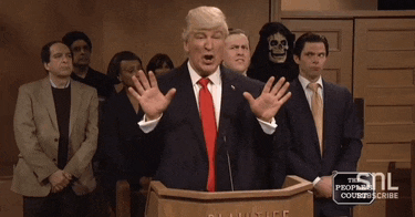 a man in a suit and tie stands at a podium with a snl logo on it