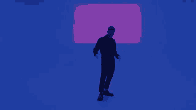 a man in a black sweater is standing in a dark room