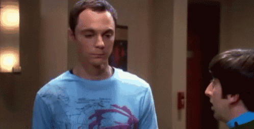 a man in a blue shirt is talking to another man in a room .