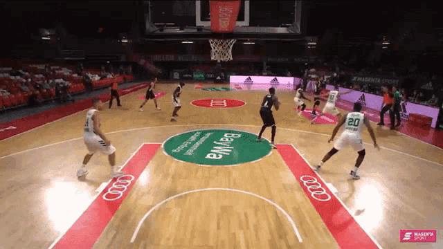 a basketball game is being played on a court with an audi logo on the floor