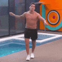 a shirtless man is standing in front of a swimming pool