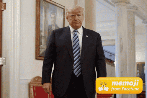 a man in a suit and tie is standing in front of a sign that says memoji from facetune