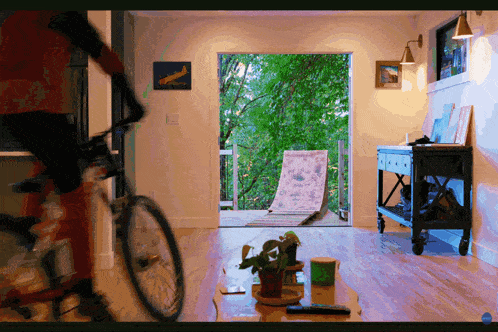 a person riding a bike in a living room with a sliding glass door