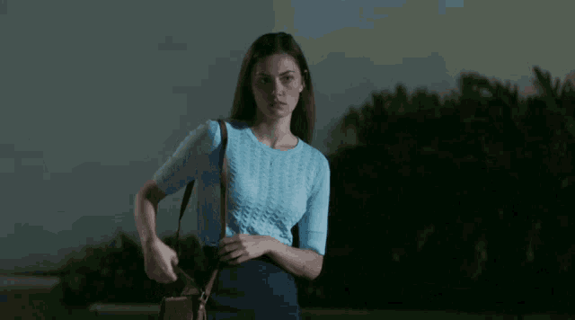 a woman wearing a blue shirt and a blue skirt