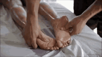a person is giving a foot massage to another person .