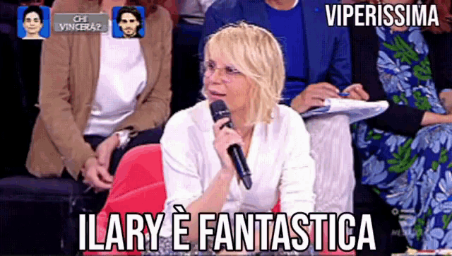 a woman speaking into a microphone with the words ilary e fantastica above her
