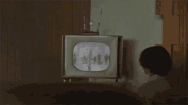 a child is watching a television with a picture of a family on it