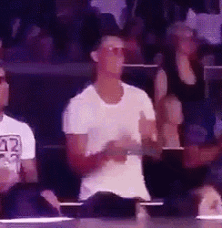 a man wearing sunglasses and a white shirt is dancing in a crowd .